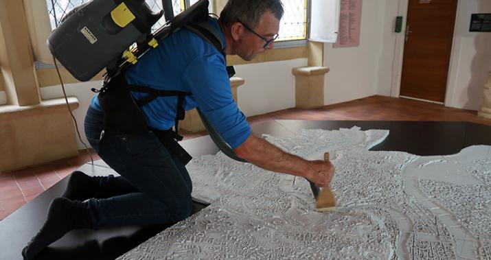 Dépoussiérage de la maquette de la ville de Lyon dans l'exposition Portraits de Lyon